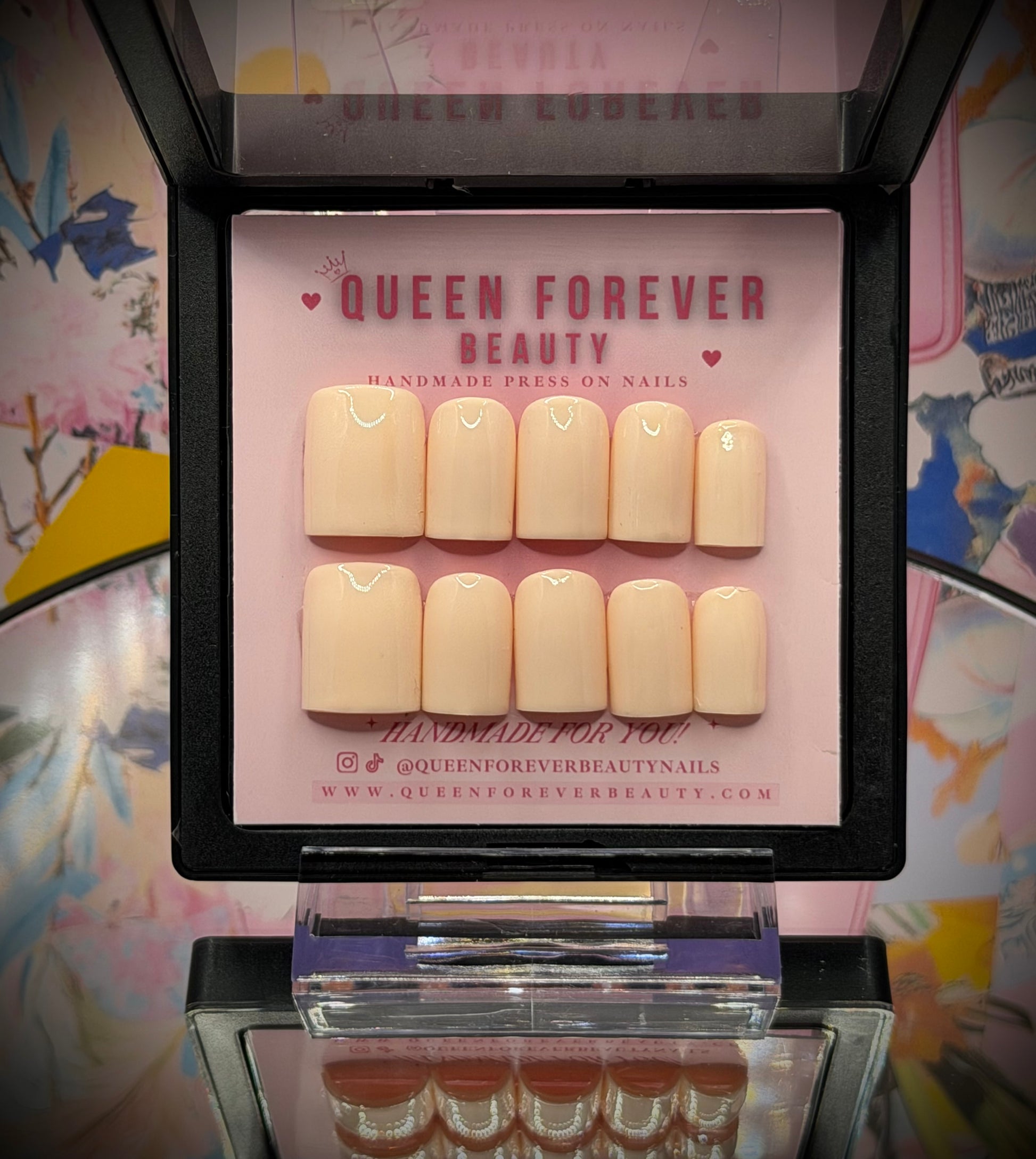 A set of 10 press-on nails in a warm nude beige color, displayed in an open black case with a pink insert card branded 'QUEEN FOREVER BEAUTY'.